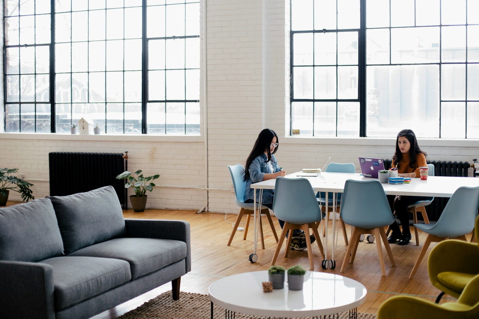 SupremeCall.com - two women sitting in front of white table