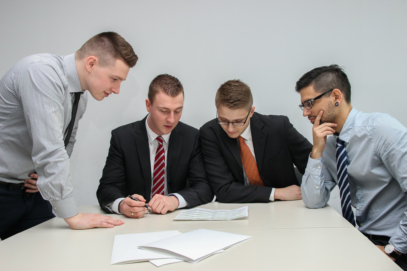 SupremeCall.com - four men looking to the paper on table